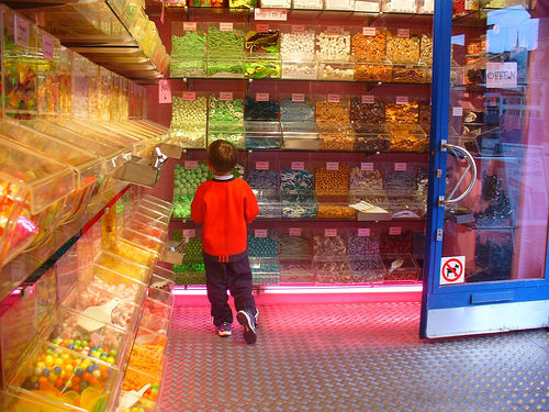 Photo: Small child looking at a wall of candy in a candy store